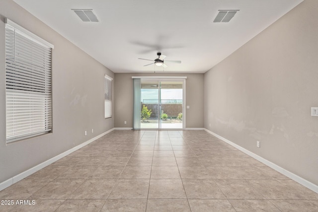 empty room with ceiling fan and light tile patterned floors