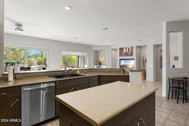 kitchen with dark brown cabinetry, a center island, sink, and stainless steel dishwasher