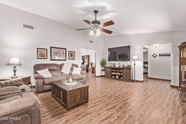 living room with ceiling fan, lofted ceiling, and wood-type flooring