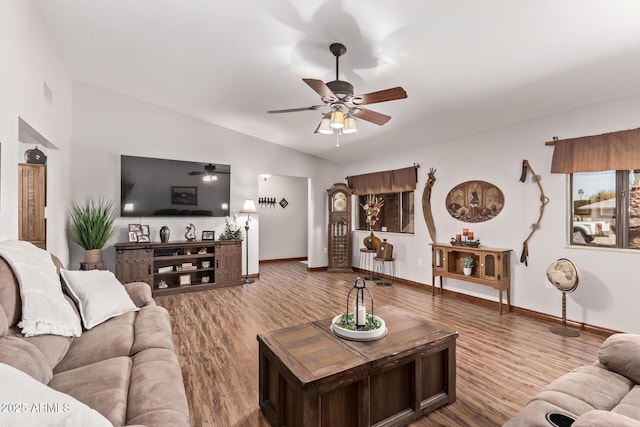 living room featuring ceiling fan, vaulted ceiling, and wood-type flooring