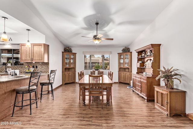 dining space with hardwood / wood-style flooring, vaulted ceiling, and ceiling fan