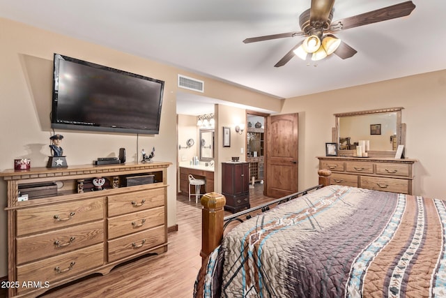 bedroom featuring ceiling fan, connected bathroom, and light hardwood / wood-style flooring