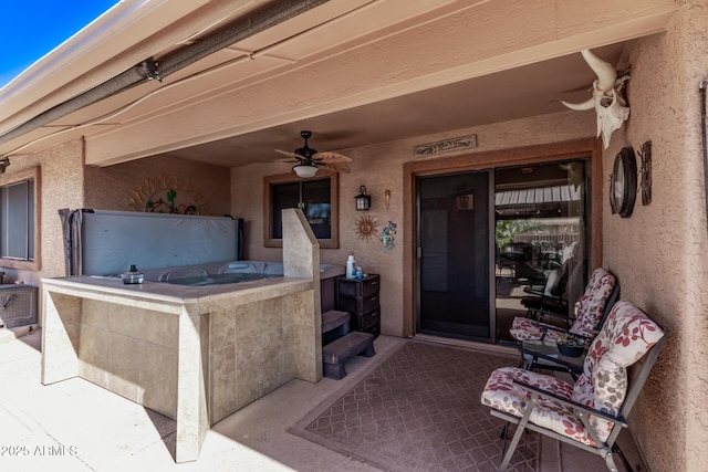 view of exterior entry featuring a patio area and ceiling fan