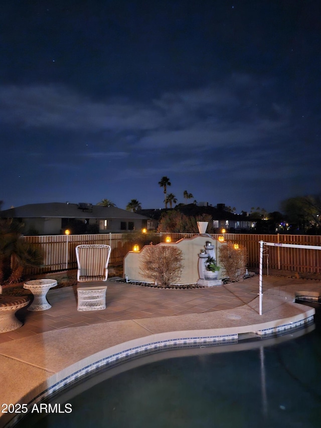 pool at twilight featuring a patio area