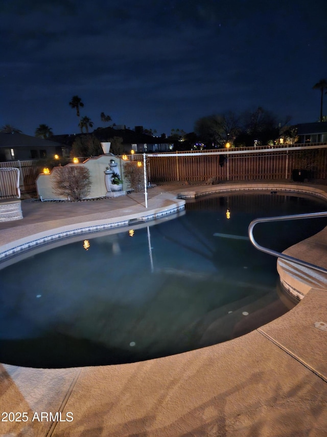 pool at twilight with a patio area