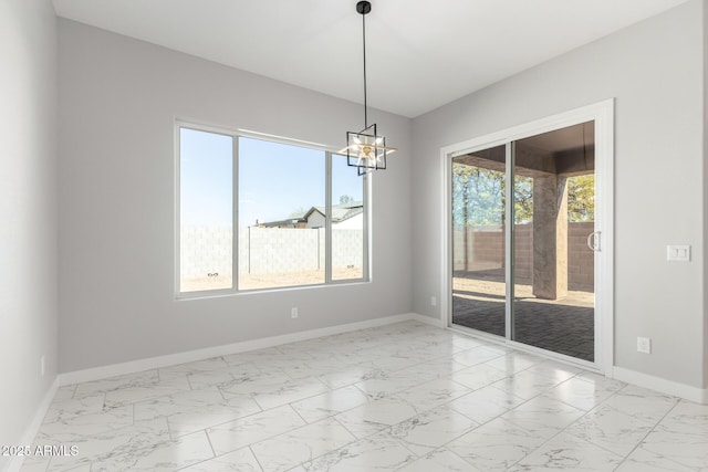 unfurnished dining area featuring a healthy amount of sunlight and an inviting chandelier