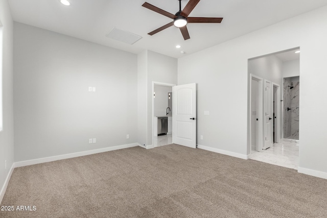 unfurnished bedroom with ensuite bathroom, ceiling fan, and light colored carpet