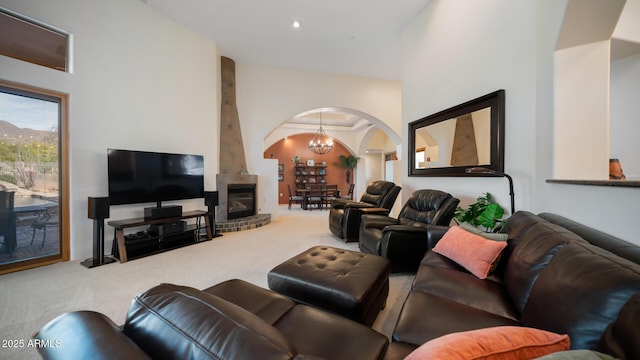 living room with a towering ceiling, an inviting chandelier, and carpet