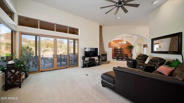 living room with light colored carpet and ceiling fan with notable chandelier