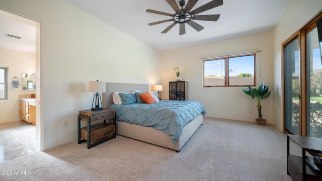 bedroom featuring connected bathroom, light carpet, and ceiling fan