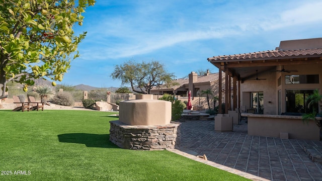 view of yard featuring ceiling fan and a patio