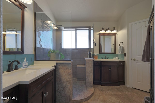 bathroom featuring a tile shower, vanity, decorative backsplash, and tile patterned floors