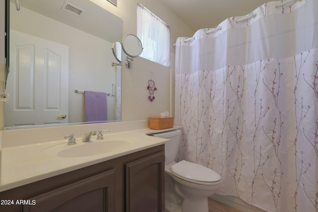 bathroom with wood-type flooring, a shower with curtain, vanity, and toilet