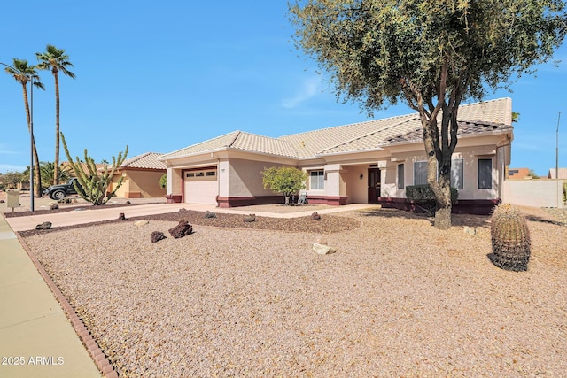 ranch-style home featuring an attached garage, stucco siding, driveway, and a tiled roof