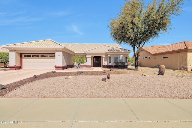 view of front of house featuring a garage, stucco siding, concrete driveway, and a tiled roof