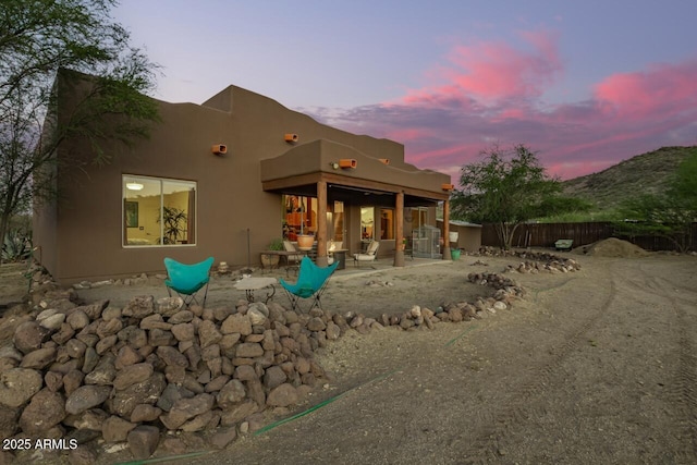 43014 N 12th St, New River, AZ 85087 - back of house at dusk featuring a patio area, fence, and stucco siding