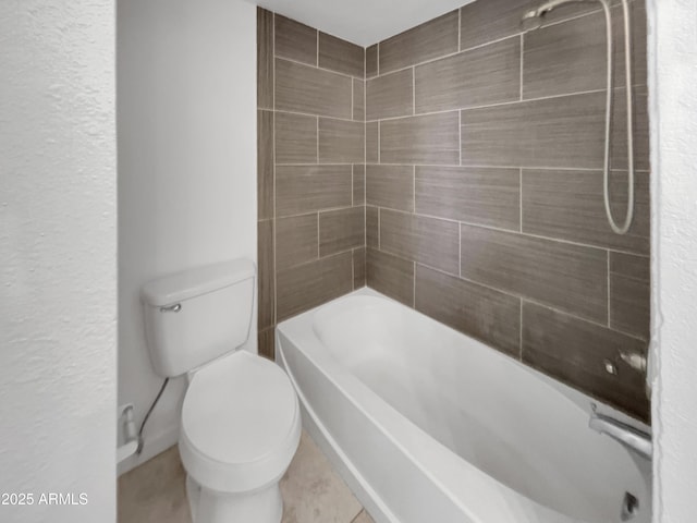 bathroom featuring toilet and tiled shower / bath