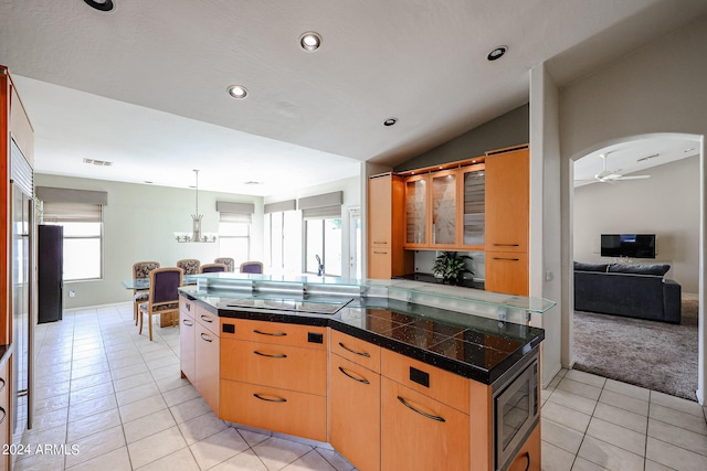656 W Johnson Dr, Gilbert, AZ 85233 - kitchen with stainless steel microwave, tile countertops, black electric stovetop, ceiling fan with notable chandelier, and vaulted ceiling