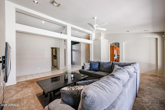656 W Johnson Dr, Gilbert, AZ 85233 - carpeted living room with vaulted ceiling, a ceiling fan, tile patterned flooring, visible vents, and arched walkways