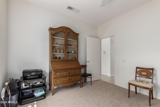 living area with light carpet and ceiling fan