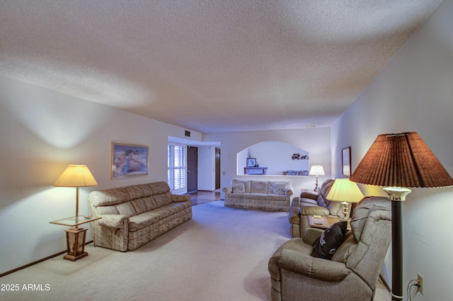 carpeted living area featuring visible vents, arched walkways, and a textured ceiling