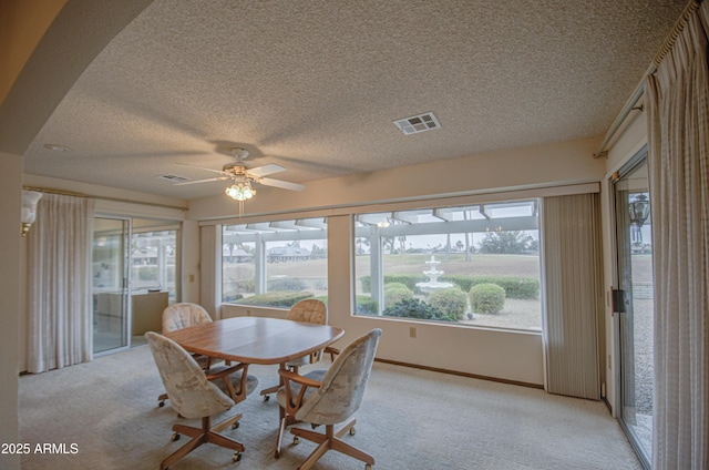 dining space with visible vents, light carpet, and a ceiling fan