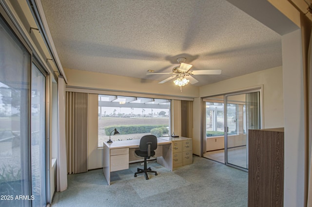 home office with light carpet, a textured ceiling, and ceiling fan