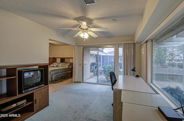 home office with a textured ceiling, visible vents, carpet floors, and ceiling fan