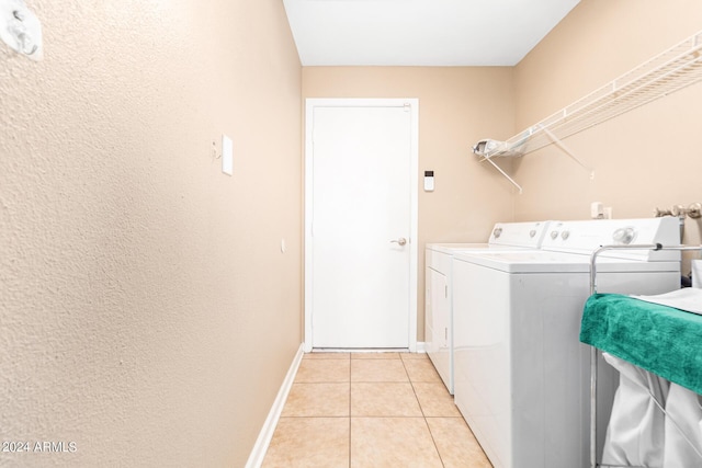 laundry room featuring light tile patterned flooring and washing machine and clothes dryer