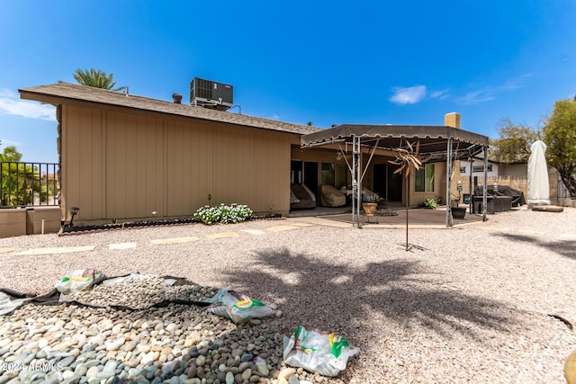 rear view of property with cooling unit and a patio