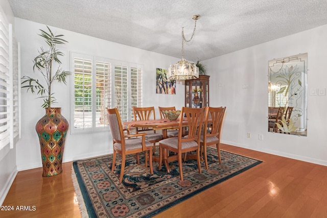 dining space featuring a textured ceiling and hardwood / wood-style flooring