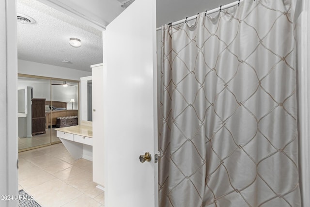 bathroom featuring a textured ceiling and tile patterned floors