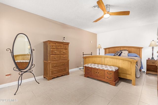 tiled bedroom with ceiling fan and a textured ceiling