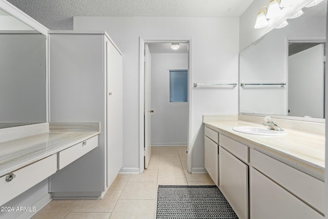 bathroom featuring a textured ceiling, tile patterned flooring, and vanity