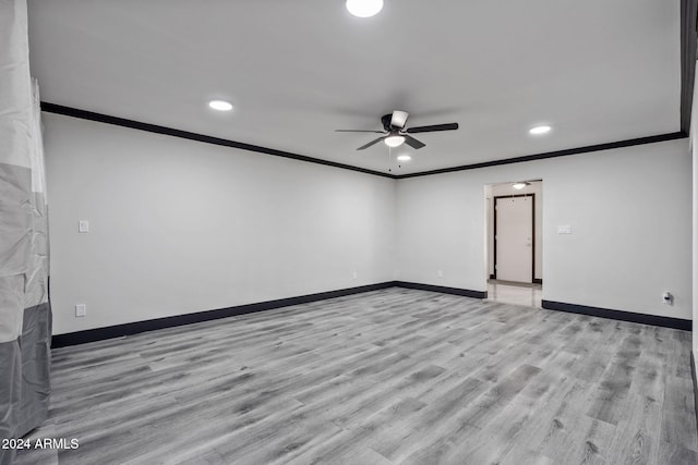 empty room with crown molding, light wood-type flooring, and ceiling fan