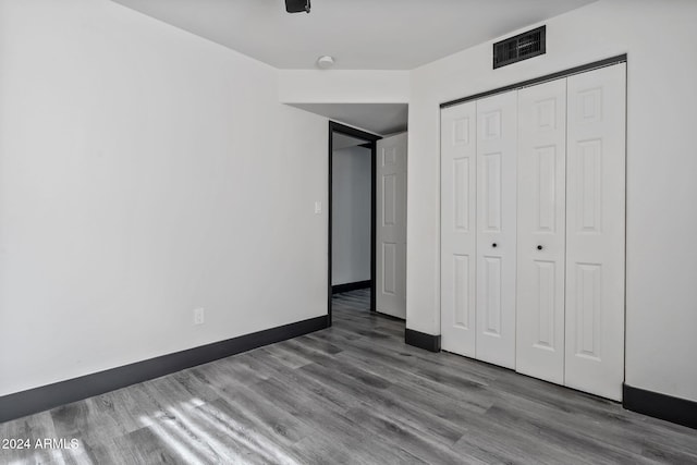 unfurnished bedroom featuring a closet and wood-type flooring