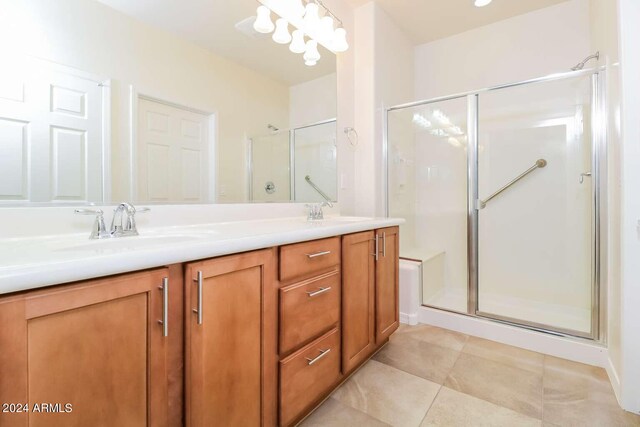 bathroom featuring walk in shower, dual sinks, tile flooring, and large vanity