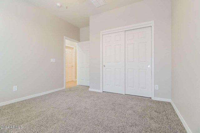 unfurnished bedroom with carpet and a closet