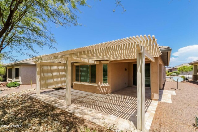 rear view of house featuring a pergola and a patio