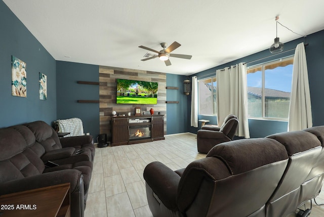 living room featuring ceiling fan, light wood-type flooring, and a fireplace