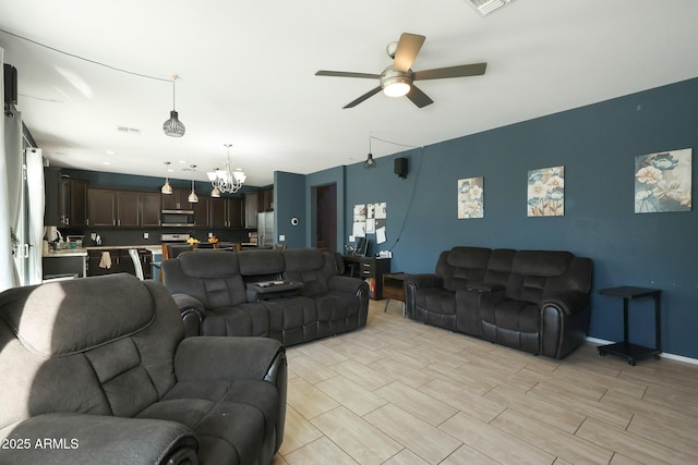 living room with ceiling fan with notable chandelier