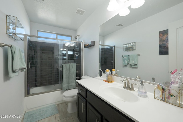 full bathroom featuring toilet, bath / shower combo with glass door, tile patterned flooring, and vanity