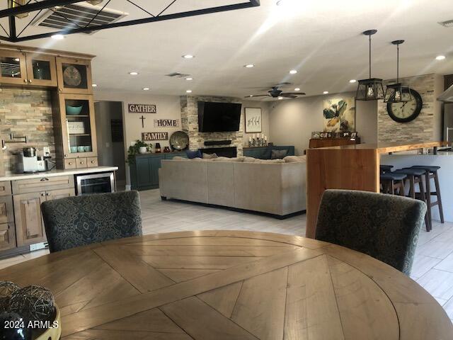 dining area with wine cooler, light hardwood / wood-style floors, and ceiling fan