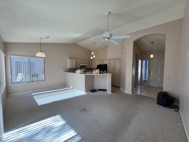 unfurnished living room featuring light carpet, a textured ceiling, vaulted ceiling, ceiling fan, and plenty of natural light