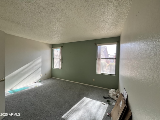 empty room with carpet, a textured ceiling, and plenty of natural light