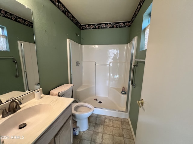 bathroom featuring vanity, an enclosed shower, and toilet