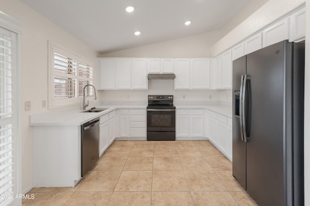 kitchen with light tile patterned floors, sink, white cabinetry, stainless steel appliances, and vaulted ceiling