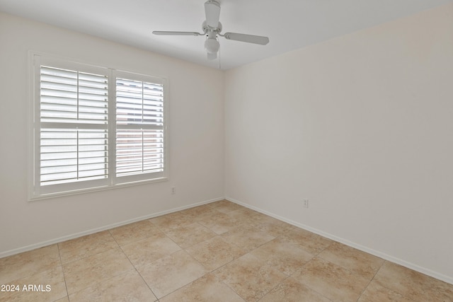 spare room with ceiling fan and light tile patterned flooring