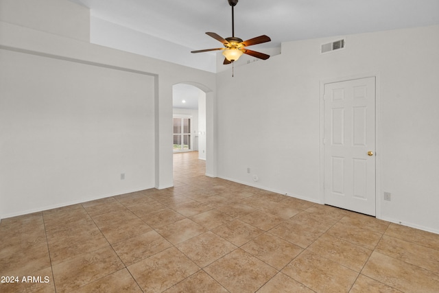 tiled empty room featuring ceiling fan and lofted ceiling