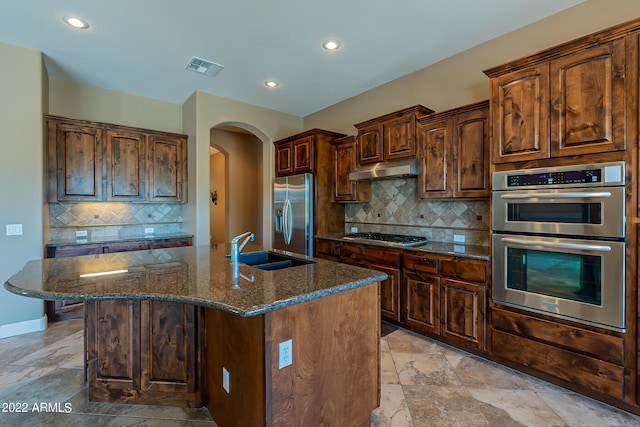 4120 E Woodside Way, Gilbert, AZ 85297 - kitchen featuring appliances with stainless steel finishes, dark stone countertops, arched walkways, recessed lighting, and backsplash